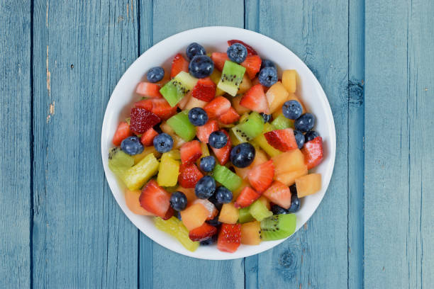 istock Cheerful Fresh Cut Fruit Salad atop a Blue Wood Background 1422722638