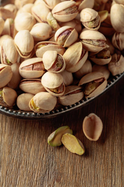 istock Salted pistachios on an old wooden table. 1422728634
