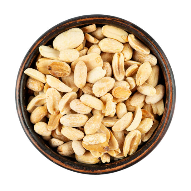 istock Peanuts, roasted and salted, in bowl isolated on white background. Shelled Arachis hypogaea, also called groundnut and goober, used as a snack. File contains clipping path. 1422730486