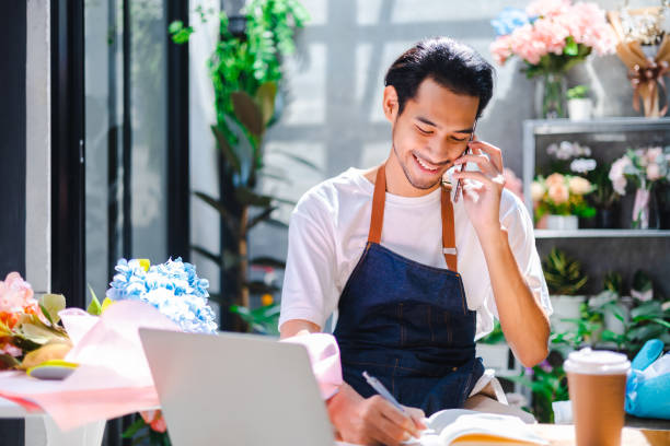 l'influencer asiatico o il proprietario di pmi sorridono lavorano sulle riprese selfie della videocamera domestica. fioraia sorridente che parla al cellulare. giovane donna che lavora al negozio con il segno open. - fioraio negoziante foto e immagini stock