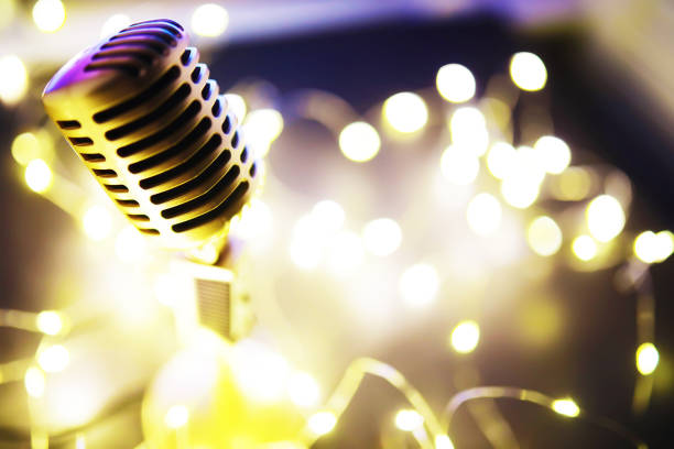 istock Retro style microphone on background backlight. Vintage Microphone for sound, music, karaoke. Speech broadcast equipment. Live pop, rock musical performance. Selective focus 1422732882