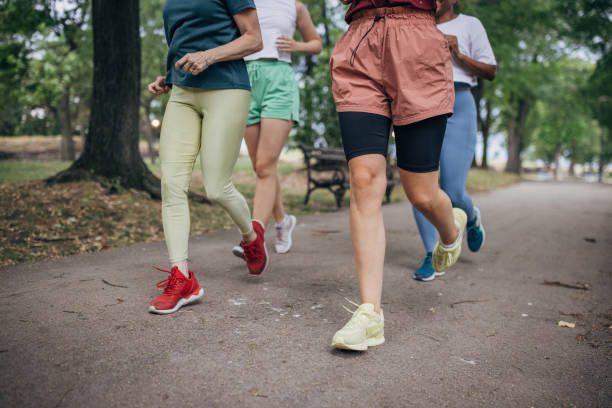 istock Female friends jogging in park 1422735017