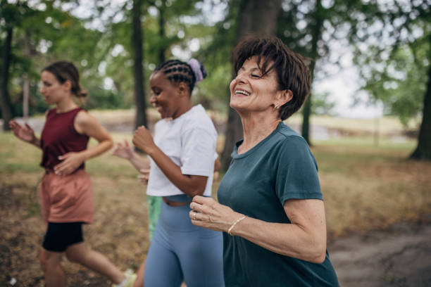 istock Female friends jogging in park 1422735320