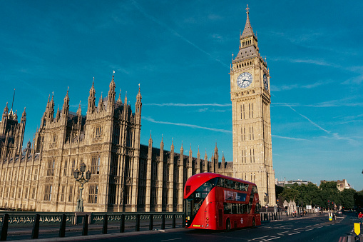 Houses of Parliament  with Big Ben and double-decker bus on Westminster Bridge in London, UK