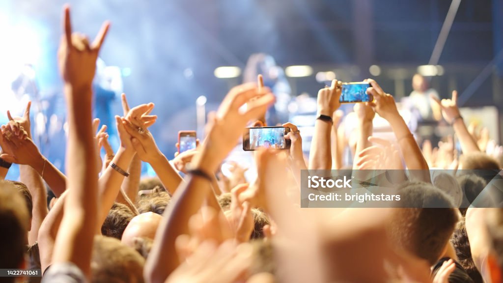 Audience in a rock concert Audience in a rock concert. Arms Raised Stock Photo