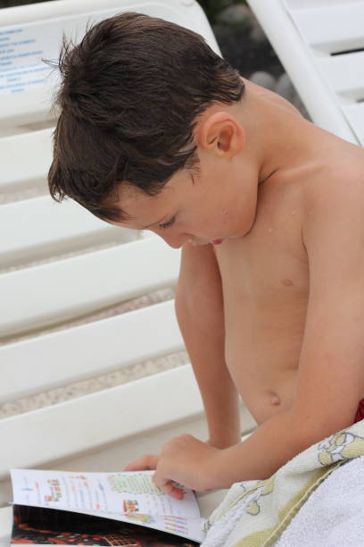 istock Young boy reading in the swimming pool 1422750080