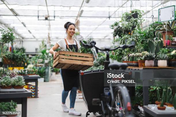 Shot Of A Young Woman Working With Plants In A Garden Centre Stock Photo - Download Image Now
