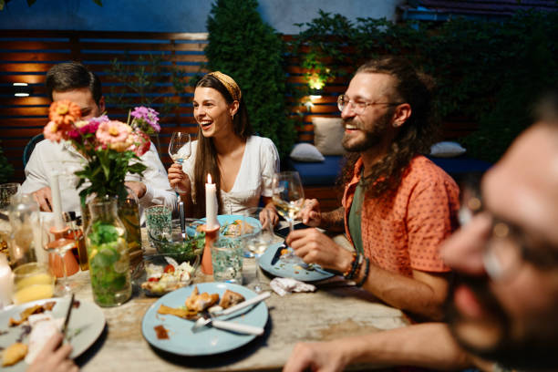 istock Cheerful friends talking while enjoying dinner at dining table in party 1422753682
