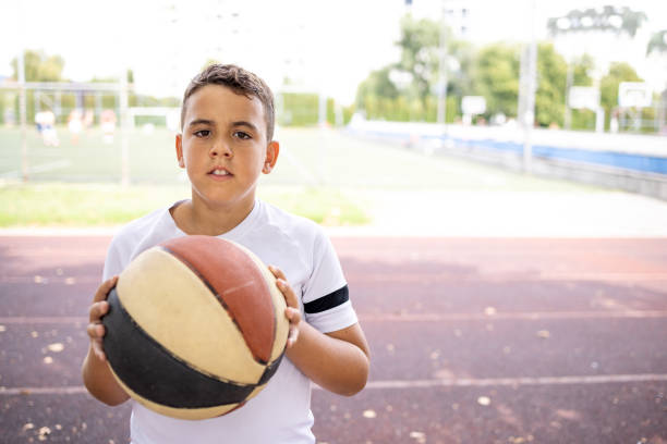 istock Boy with basketball standing in yard 1422755401