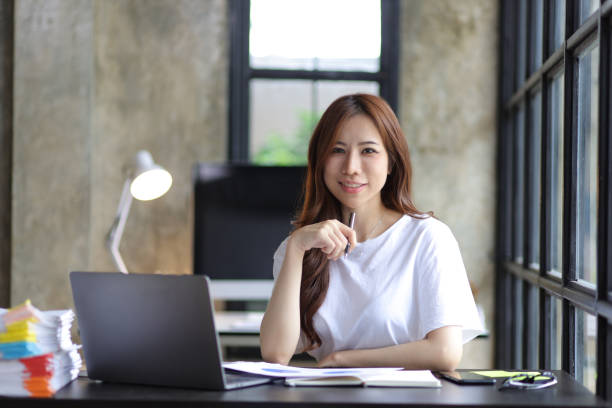 istock Casually dressed Asian woman working on laptop and documents in home office. Work from home concept. 1422755554