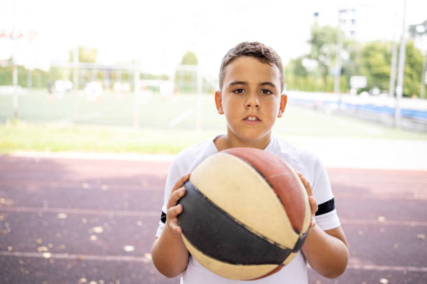 istock Boy with basketball standing in yard 1422756609