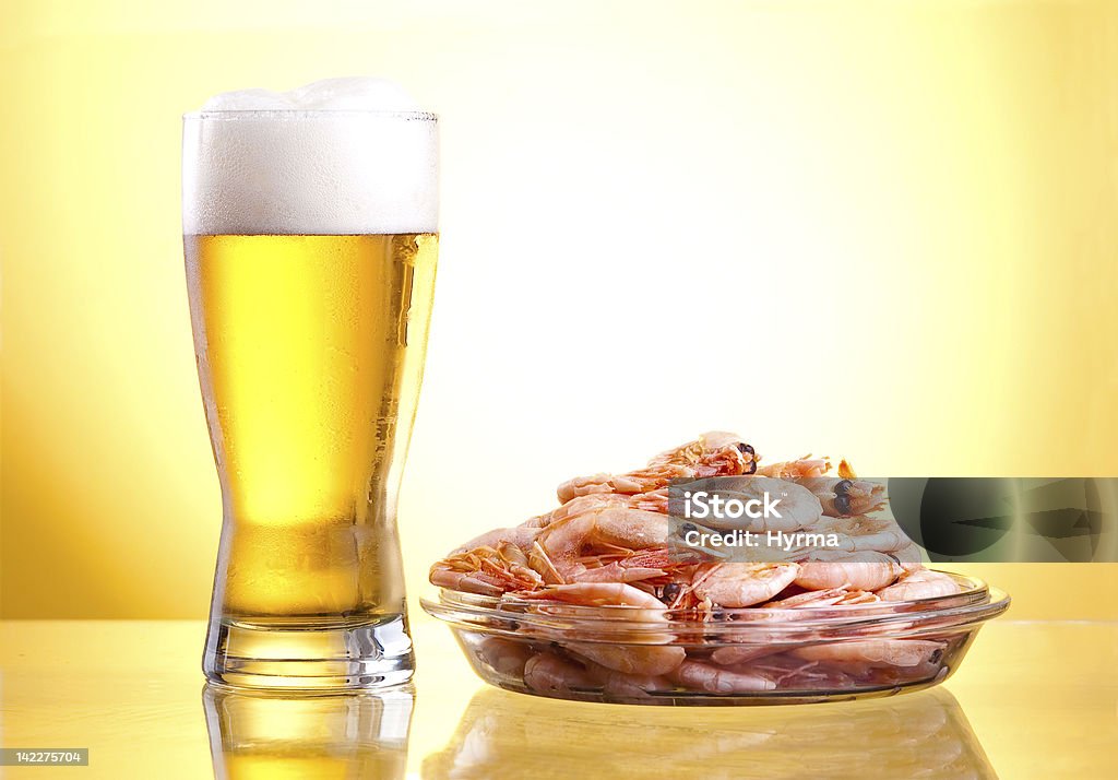 Um copo de cerveja e camarão cozido em um prato - Foto de stock de Cerveja royalty-free