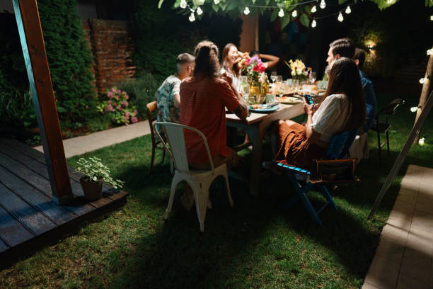 istock Cheerful friends talking while enjoying dinner at an outdoor party 1422759136