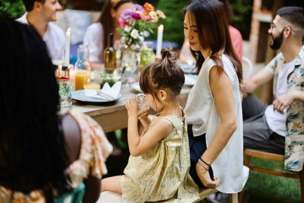 little girl drinking water during dinner - drinking little girls women wine imagens e fotografias de stock