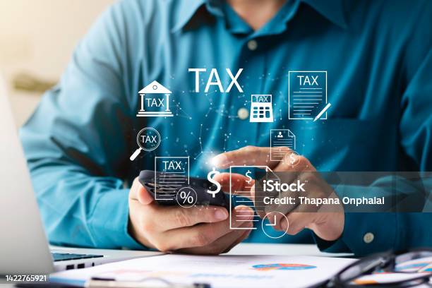 Businessman Using His Laptop Computer And Smartphone To Fill Out Online Personal Income Tax Return Form For Tax Payment Personal Income Tax Calculation Stock Photo - Download Image Now