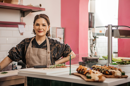 An expert female vegan sushi chef professional preparing tasty food in a local restaurant