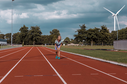 Athletic girl working hard on the running track