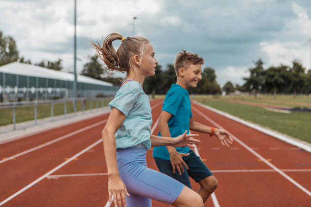 Two athletic children working hard on the running track