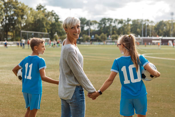 Soccer mother football coach with her children during a training session stock photo