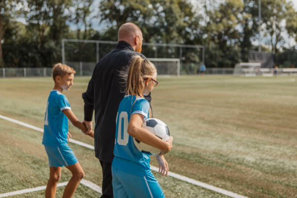 istock Soccer football coach with two children during a training session 1422771349