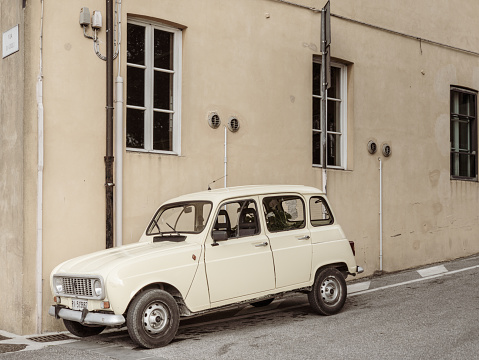 Lorenzana, Italy - April 30, 2022: a classic vintage Renault 4 car is parked in one of the streets of an ancient Tuscan village.