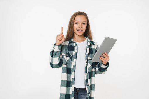 Smart caucasian preteen teenager schoolgirl using digital tablet having idea for online education, homework, remote lessons, social media isolated in white background