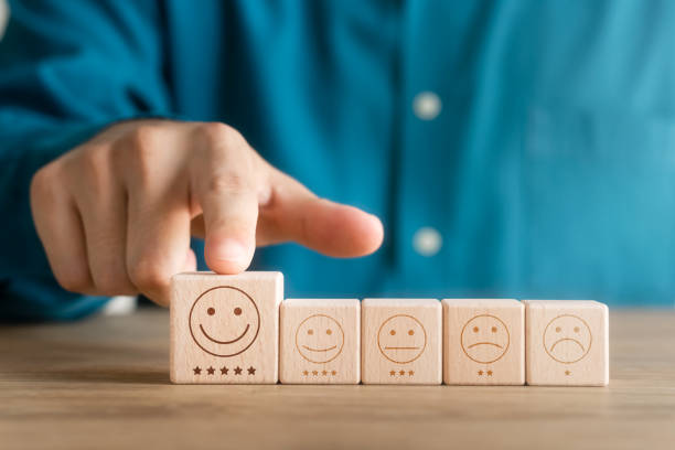 istock Customer satisfaction survey concept, customer hand selects wooden cube with smile face icon, best service excellence rating for satisfaction. 1422778199