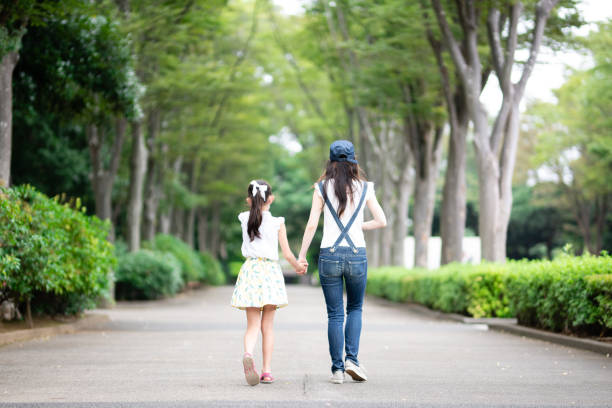 istock mother and daughter walking hand in hand 1422781751