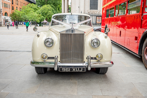 London, UK - 1 April, 2021: an old vintage white Cadillac car parked on a residential city street in London, UK.