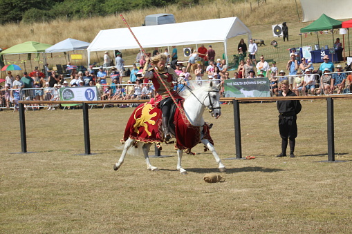 Waterlooville, UK - 14 August, 2022: A group of talented horse riders recreating a medieval jousting tournament at a show in Hampshire.