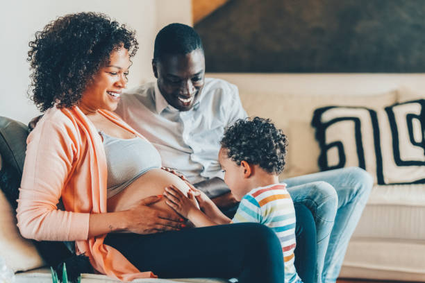 istock Boy with hands on mother’s belly feeling the baby’s movements and kicks 1422790537