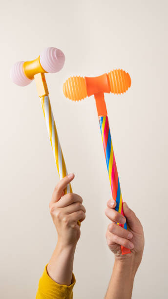 Hands with toy hammers against light background stock photo