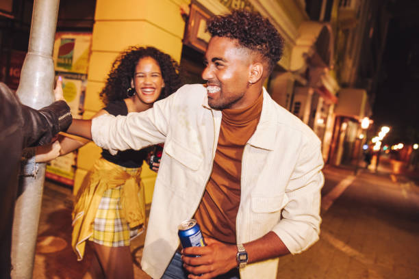 istock Joyful friends playing around a pole at night 1422792604