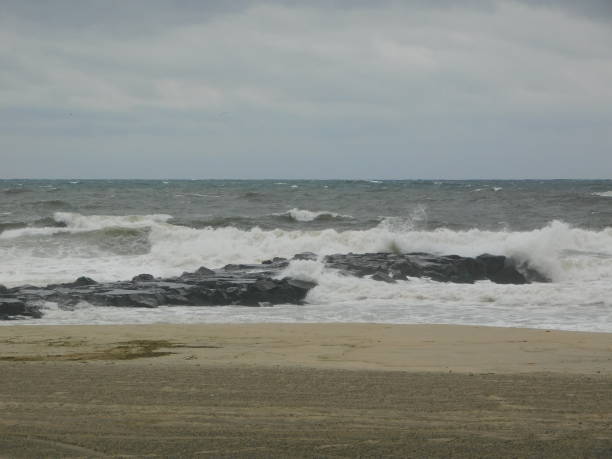 istock Before the storm waves crashing on rocks 1422792623