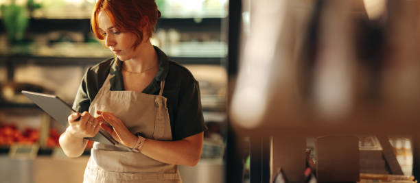 istock Female shop owner using a digital tablet in her grocery store 1422793994