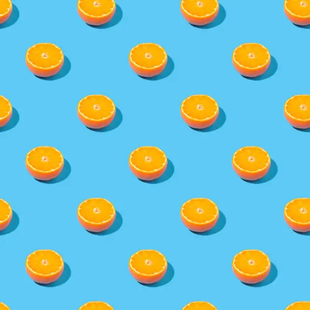 Seamless summer background with halves of oranges - absolutely seamless pattern with citruses on a blue background