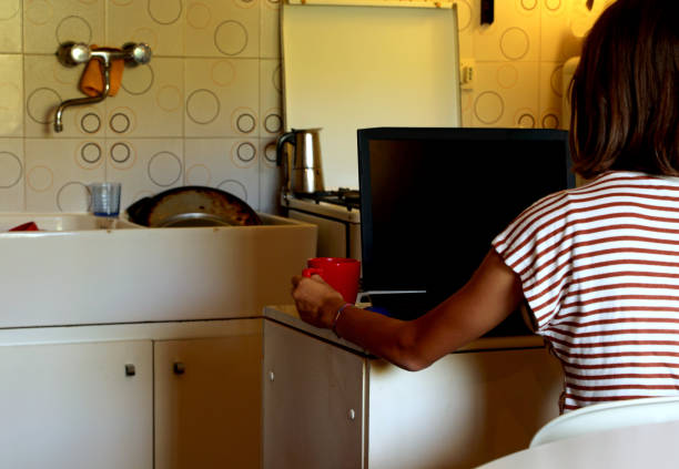 menina na cozinha do mini apartamento usa o laptop - home studio - fotografias e filmes do acervo