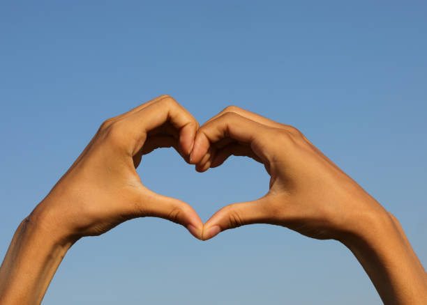istock two joined hands forming a heart on the sky 1422803403