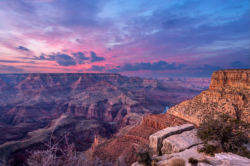 A view of the rugged yet beautiful and dramatic Grand Canyon national park during a moody sunset shows the intricate details of the ridges and formations.