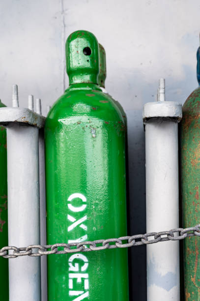 istock Compressed gas cylinders being stored vertically secured by a metal chain and a metal cap. 1422804497
