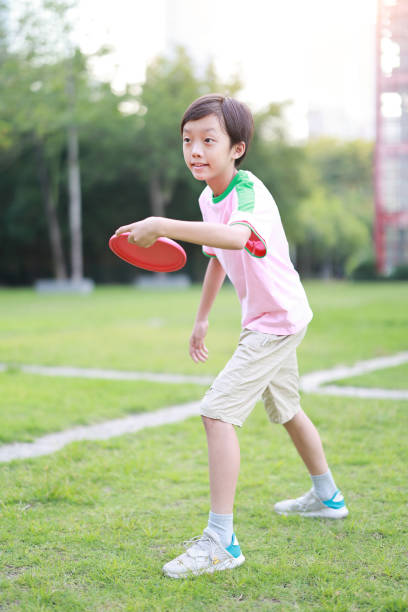 istock Little boy plays frisbee in park 1422804778