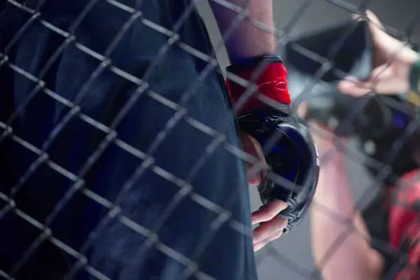 Photo of concept of mixed martial arts. MMA.  close up hand and cage is a metal wire