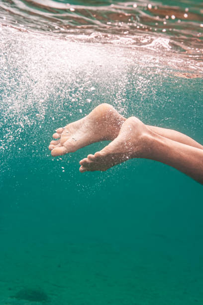 istock Feet of young boy under sea surface. 1422806649