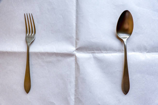 istock A fork and a spoon on a wrinkled white background 1422806917