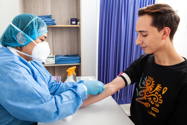 Young Female nurse collecting a blood sample from a male patient in a clinic Young Female nurse collecting a blood sample from a male patient in a clinic wafid medical appointment test stock pictures, royalty-free photos & images