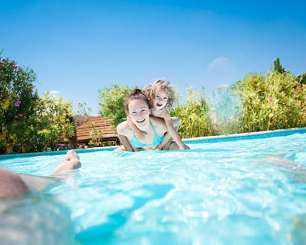 istock Happy family playing in swimming pool 142281022