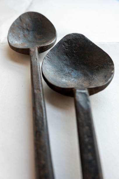 istock Close-up of two old iron spoons on white background 1422814373