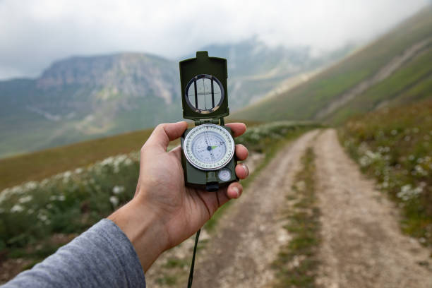 istock Man with compass in hand on mountains road 1422814483
