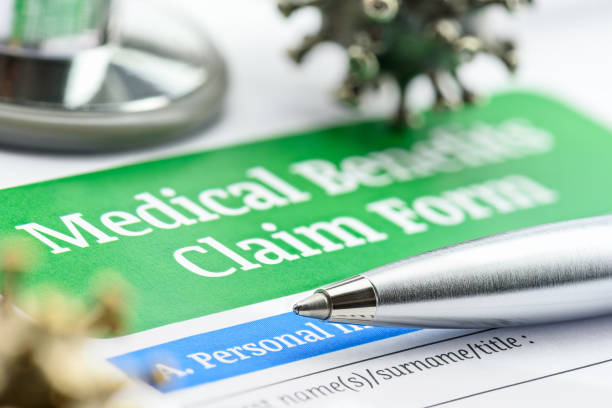Covid-19 insurance claim, disease caused by a virus, healthcare concept : Coronavirus model on a health benefits form with a pen and a stethoscope, a patient's insurance policy will cover all costs. reclamación de seguro covid-19, enfermedad causada por un virus, concepto de atención médica: modelo de coronavirus en un formulario de beneficios de salud con un bolígrafo y un estetoscopio, la póliza de seguro de un paciente cubrirá todos los costo