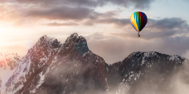 istock Dramatic Mountain Landscape covered in clouds and Hot Air Balloon Flying. 1422816339